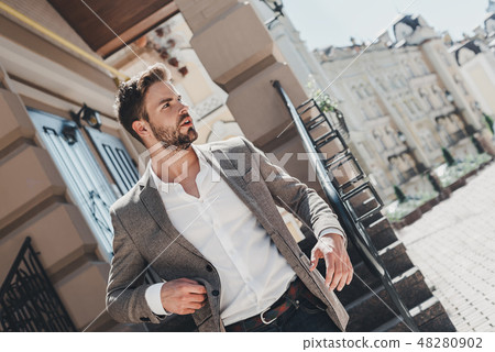 Learn to let go. That is the key to happiness. Serious brown-haired man standing outdoors after a Learn to let go. That is the key to happiness. Serious brown-haired man standing outdoors after a 48280902