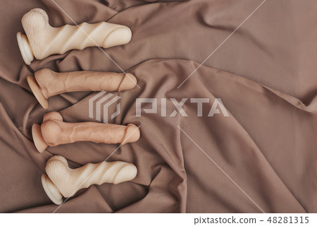 Adult Toys for Sexual Pleasure. Collection of skin realistic dildos in various sizes arranged on a Adult Toys for Sexual Pleasure. Collection of skin realistic dildos in various sizes arranged on a 48281315