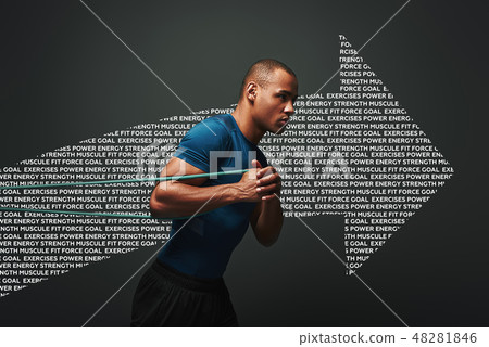Pushing hard. Sportsman working out with resistance band over dark background Pushing hard. Sportsman working out with resistance band over dark background 48281846