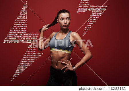 Pure perfection. Sportswoman standing over red background Pure perfection. Sportswoman standing over red background 48282181