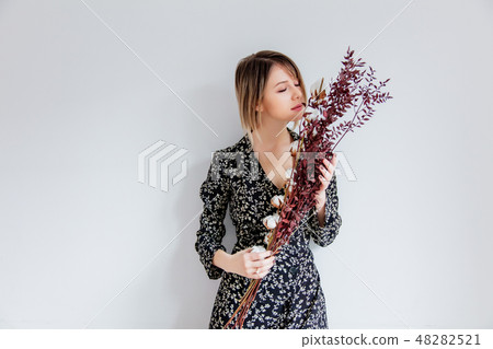 Beautiful woman in trendy dress with cotton branch  48282521
