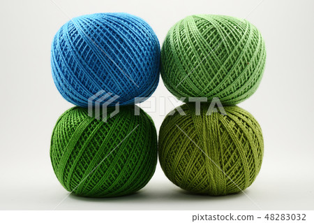 four skeins of wool on a white 48283032