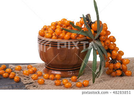 Sea-buckthorn berries in a wooden bowl on table isolated  white background 48283851