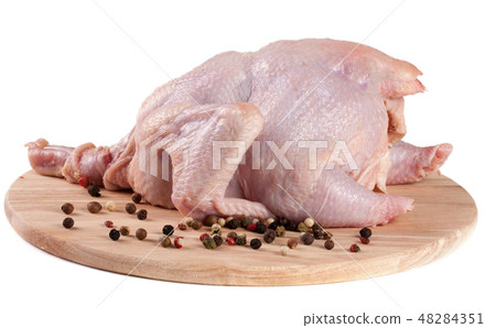 raw chicken carcass with peppercorns on the cutting board isolated on white background 48284351