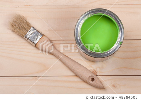 green paint in the bank to repair and brush on the light wooden background green paint in the bank to repair and brush on the light wooden background 48284503