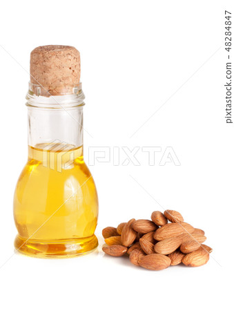 Bottle of almond oil and almonds isolated on white background Bottle of almond oil and almonds isolated on white background 48284847