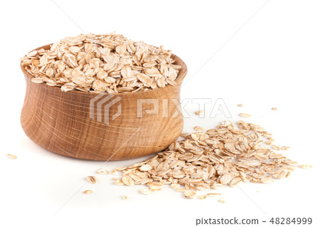 oat flakes in a wooden bowl isolated on white background 48284999