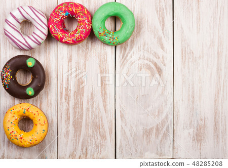 glazed donuts on a white wooden background with copy space for your text. Top view glazed donuts on a white wooden background with copy space for your text. Top view 48285208