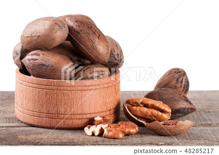 pecan nuts in a wooden bowl on the old board pecan nuts in a wooden bowl on the old board 48285217