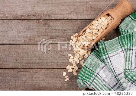 Oat flakes in a wooden scoop on old wooden background with copy space for your text. Top view 48285383