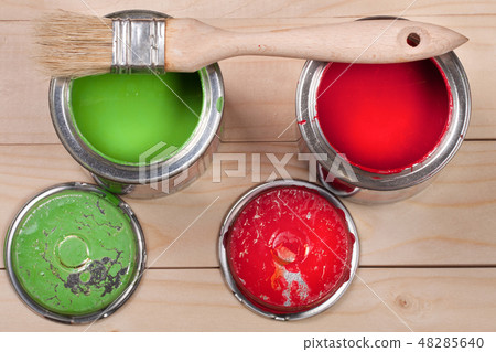 green and red paint in the bank to repair and brush on the light wooden background green and red paint in the bank to repair and brush on the light wooden background 48285640