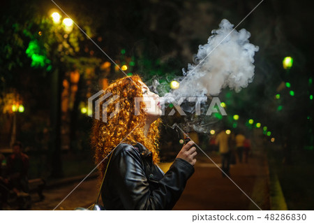 Girl smokes electronic cigarette 48286830