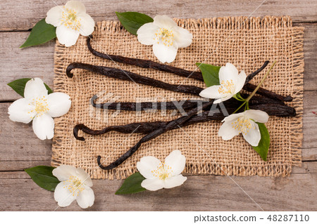 Vanilla sticks with flower and leaf on a old wooden background Vanilla sticks with flower and leaf on a old wooden background 48287110