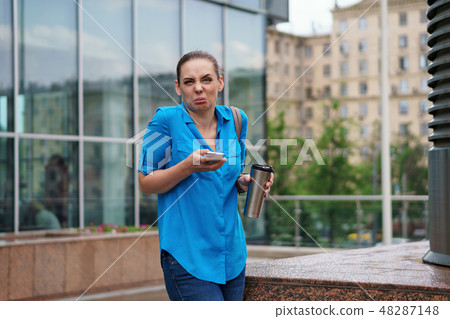 Girl with cell phone and coffee Girl with cell phone and coffee 48287148
