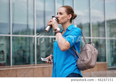 Girl with cell phone and coffee Girl with cell phone and coffee 48287151