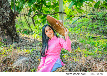 Beautiful girl wearing a pink posing in the park. Beautiful girl wearing a pink posing in the park. 48288789