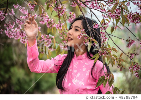 Beautiful girl wearing a pink posing in the park. Beautiful girl wearing a pink posing in the park. 48288794
