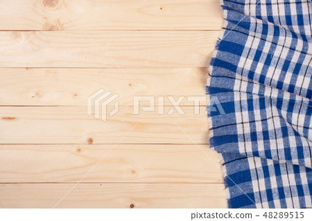 blue checkered tablecloth on a light wooden table with copy space for your text. Top view 48289515