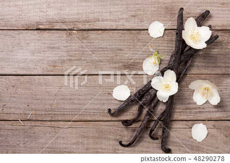 Vanilla sticks with flower and leaf on a old wooden background with copy space for your text. Top Vanilla sticks with flower and leaf on a old wooden background with copy space for your text. Top 48290278