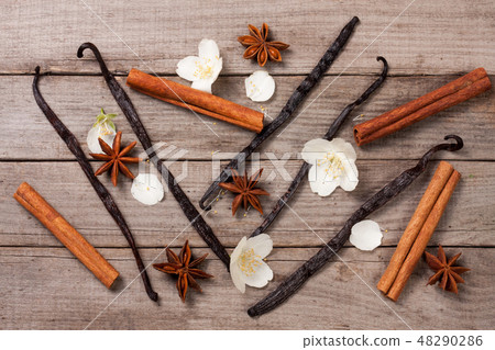 Vanilla sticks and cinnamon with anise and flower on a old wooden background Vanilla sticks and cinnamon with anise and flower on a old wooden background 48290286