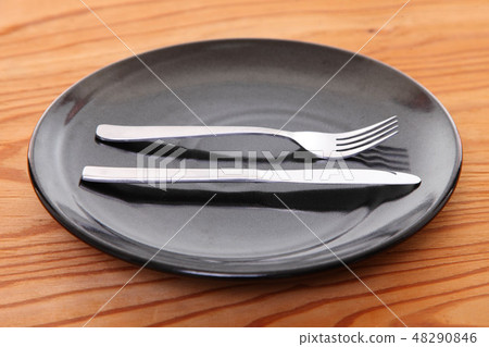 與黑色盤子和在一張木桌安置的利器的巨大滿意標誌 48290846