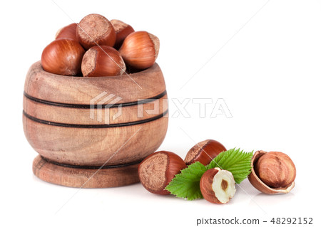 Hazelnuts with leaves in a wooden bowl isolated on white background Hazelnuts with leaves in a wooden bowl isolated on white background 48292152
