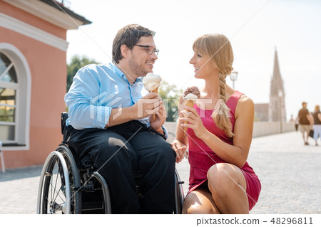 Disabled man and his friend having ice cream in town 48296811
