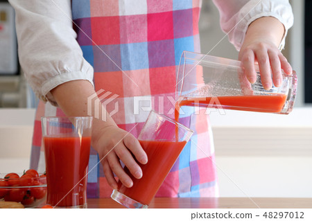 Housewife pouring tomato juice 48297012