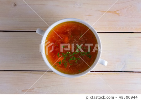 Rich beef broth in small soup bowl  48300944
