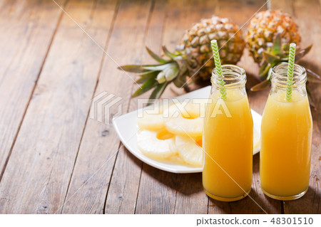 bottles of pineapple juice with fresh fruits 48301510