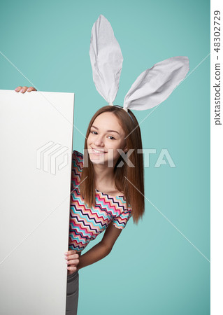 Girl wearing bunny ears holding a banner 48302729