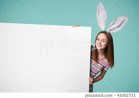 Girl wearing bunny ears holding a banner 48302731