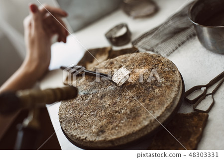 Hot silver. Close up of hot silver ring on jeweler's workbench after soldering. Jeweler's working Hot silver. Close up of hot silver ring on jeweler's workbench after soldering. Jeweler's working 48303331