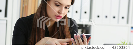 Beautiful brunette smiling businesswoman hold in arm cellphone Beautiful brunette smiling businesswoman hold in arm cellphone 48303864