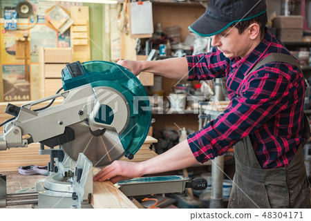 Construction worker cutting wooden board 48304171
