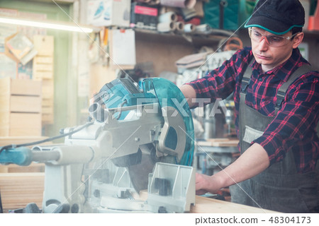 Construction worker cutting wooden board Construction worker cutting wooden board 48304173