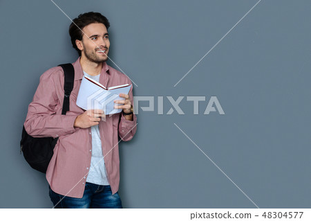 Cheerful male tourist reading a tour guide Cheerful male tourist reading a tour guide 48304577