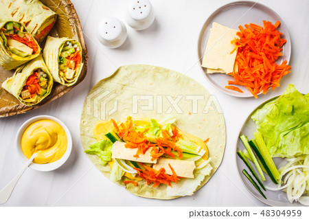 Cooking vegan tofu wraps with cashew cheese sauce Cooking vegan tofu wraps with cashew cheese sauce 48304959