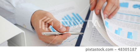 Male hands hold documents with financial statistic Male hands hold documents with financial statistic 48305187
