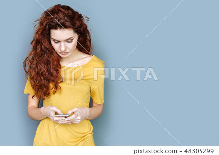 Nice red haired woman typing a message Nice red haired woman typing a message 48305299
