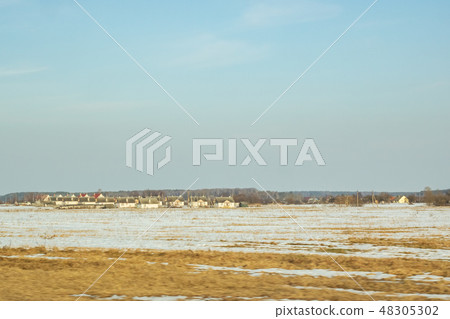 Winter sunny landscape, field forest and houses Winter sunny landscape, field forest and houses 48305302