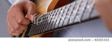 Male arms playing classic shape electric guitar Male arms playing classic shape electric guitar 48305303