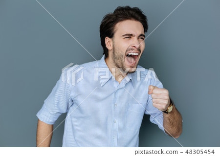 Positive emotional man holding a microphone Positive emotional man holding a microphone 48305454