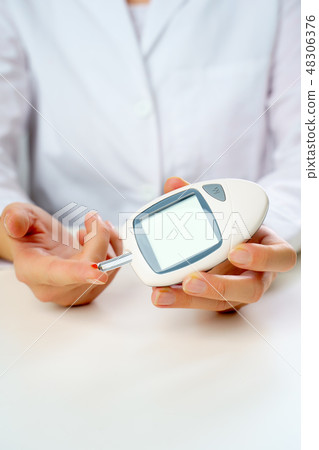 Picture of patient's hand with glucometer. 48306376
