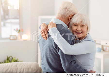 Cheerful elderly woman posing while hugging her husband 48306378