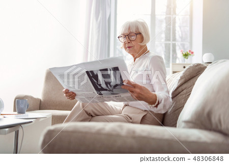 Pretty senior lady being immersed into reading newspaper 48306848