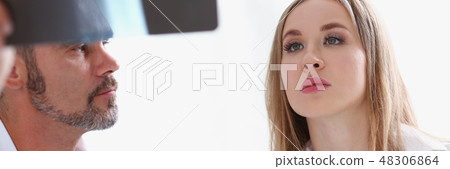 Mature male doctor hold in arm and look at xray Mature male doctor hold in arm and look at xray 48306864