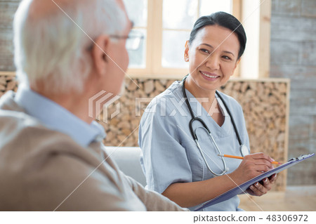 Happy doctor writing down senior mans symptoms 48306972