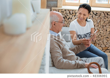 Handsome senior man demonstrating photo to volunteer 48306991