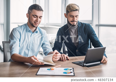 Two businessman in office having discussion in front of computer Two businessman in office having discussion in front of computer 48307134